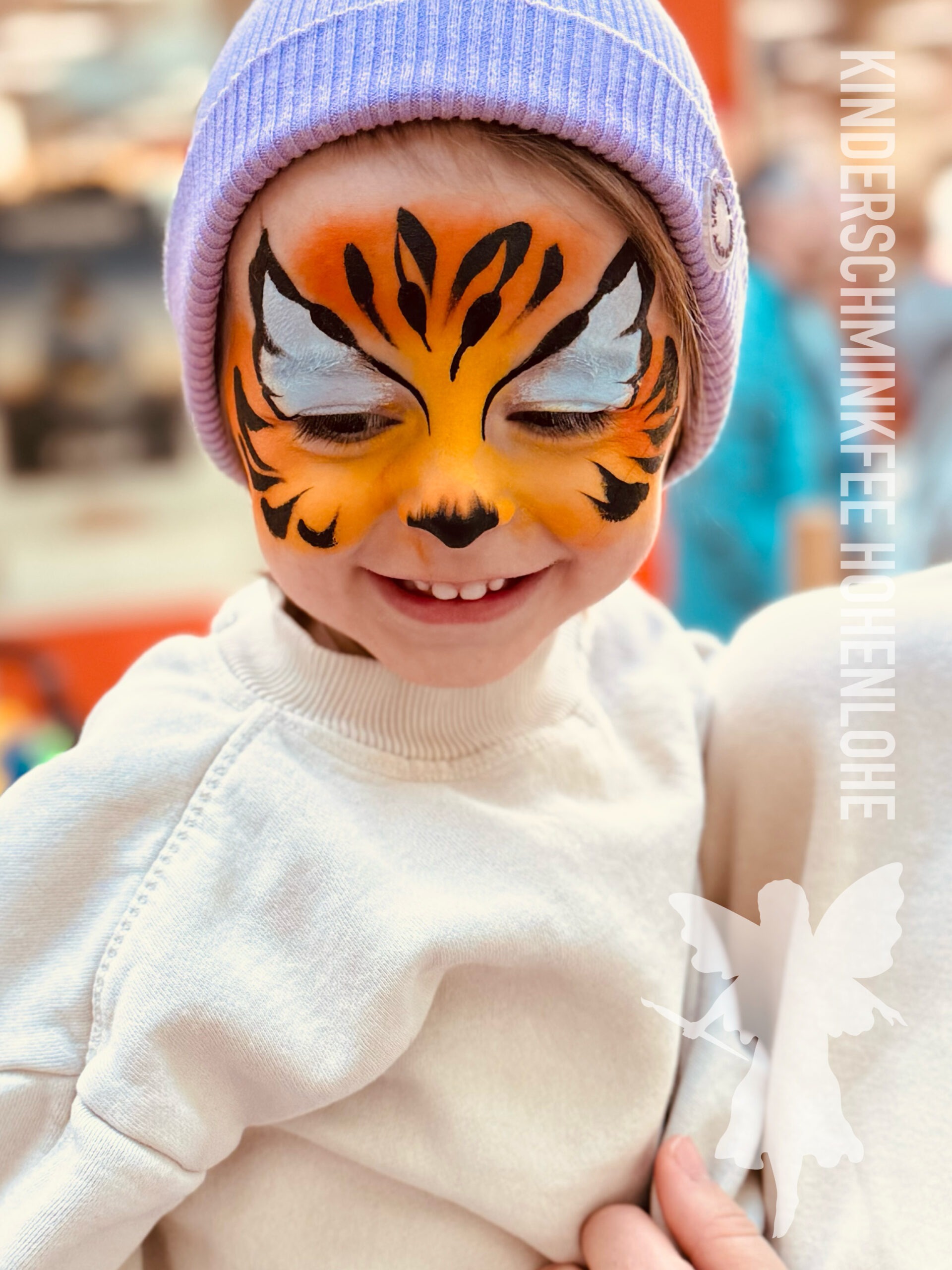 Kleines Mädchen mit einem Tiger im Gesicht, vom Kinderschminken in Hohenlohe und Heilbronn