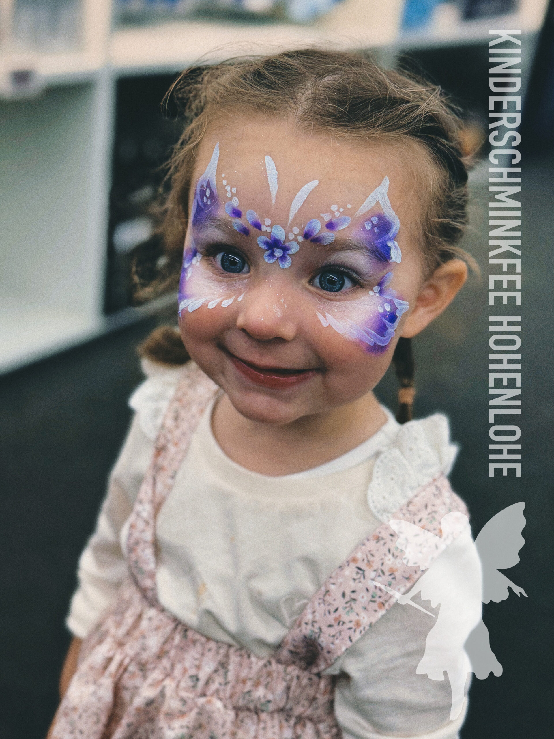 Kind mit einem Schmetterling beim Kinderschminken in Hohenlohe
