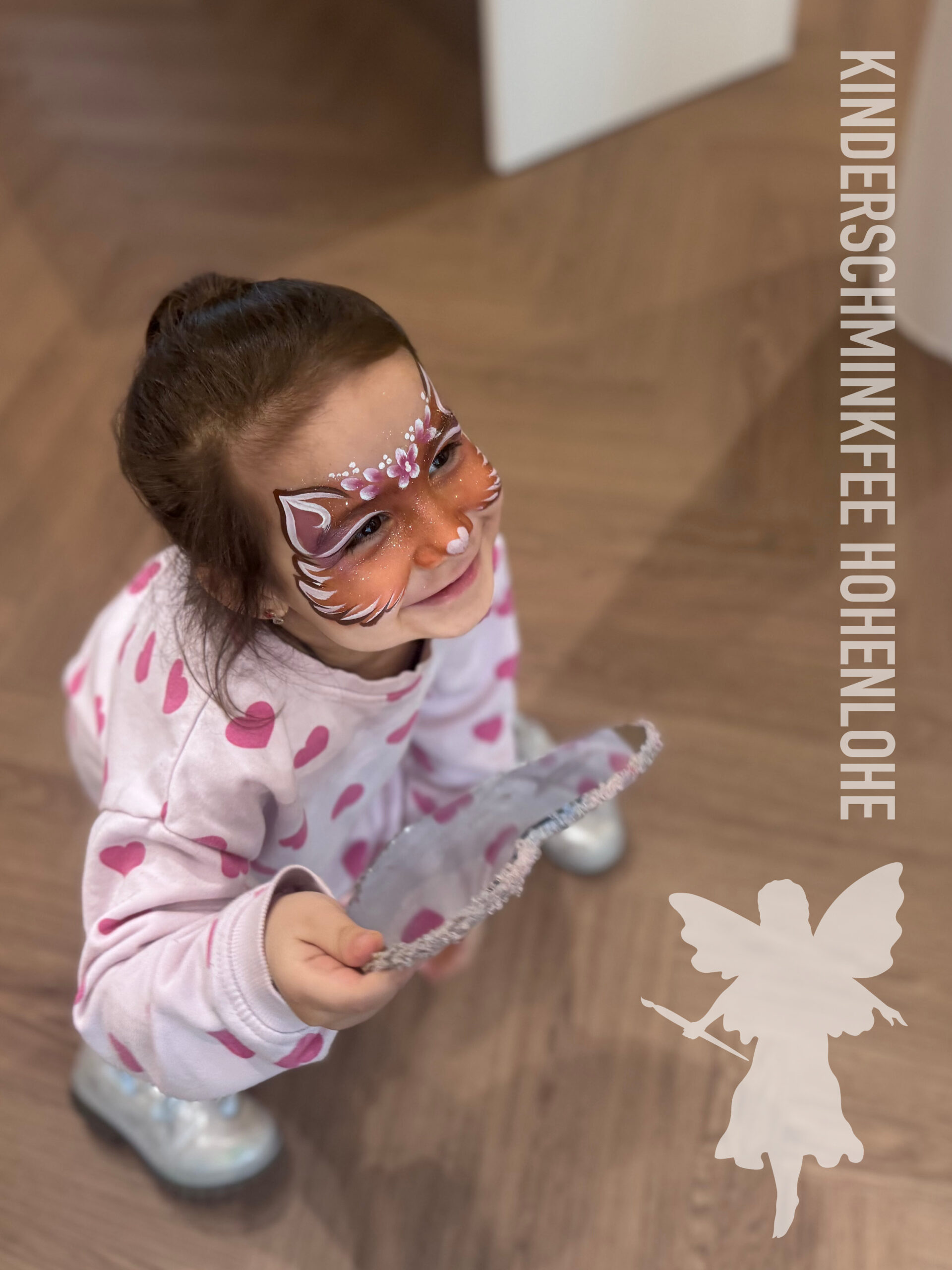 Kind mit einer Katze beim Kinderschminken in Hohenlohe