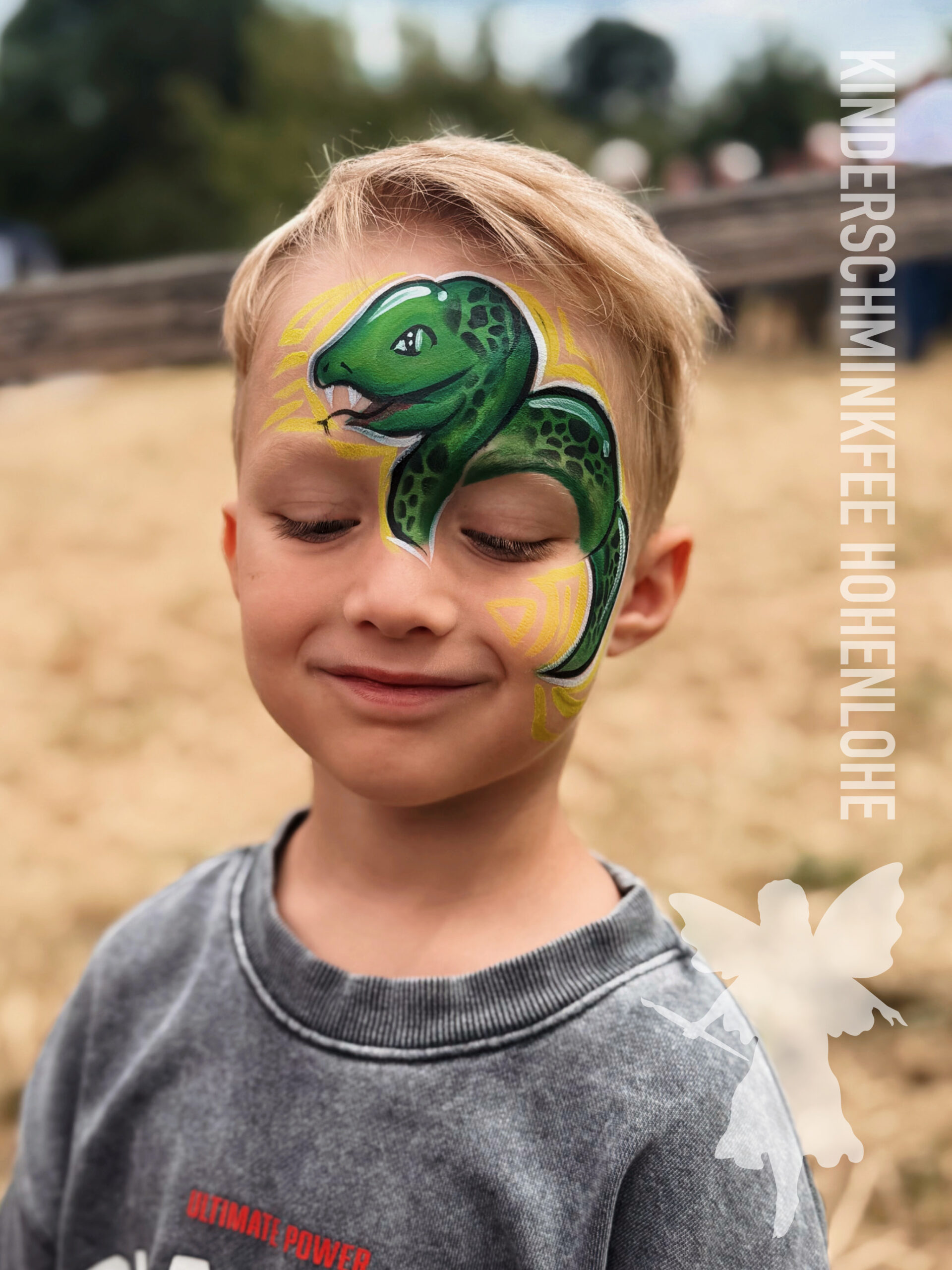 Kind mit einer Schlange beim Kinderschminken in Hohenlohe